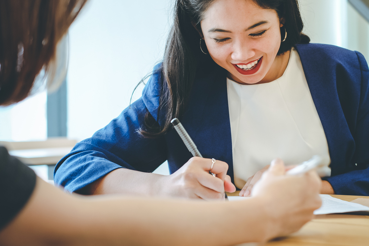 Woman Signing Document at an Office